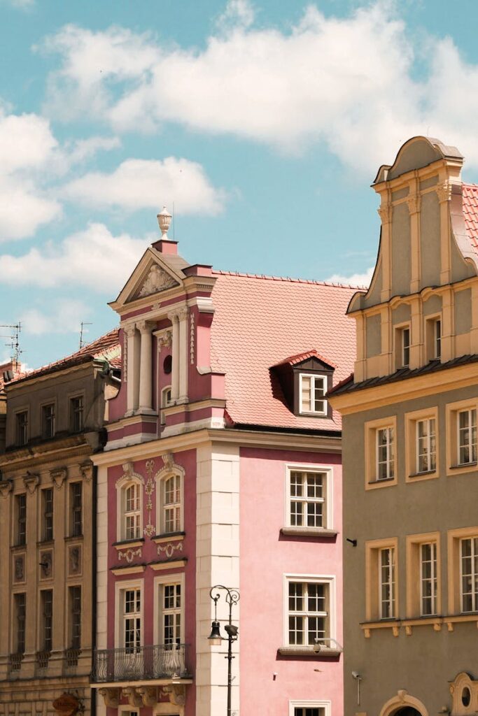 Colorful historic facades in Poznań, Poland under a bright blue sky.